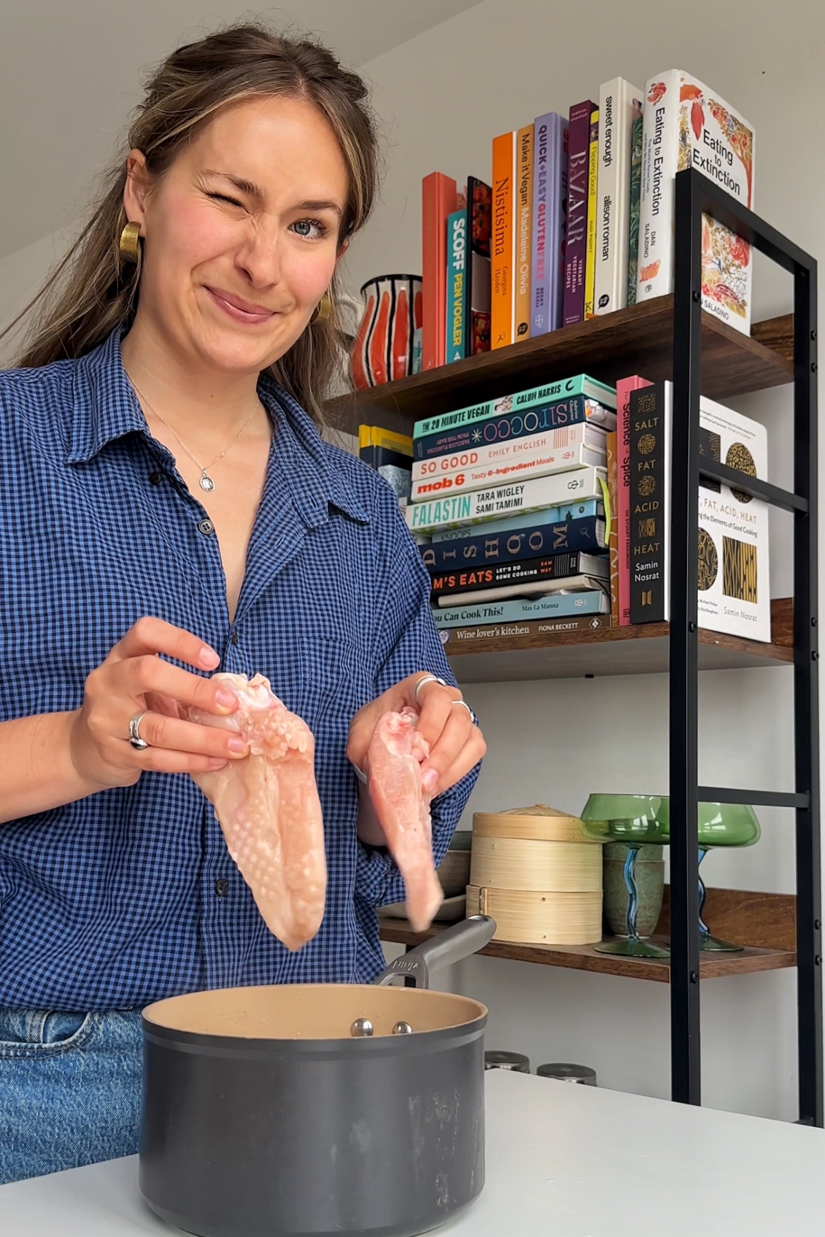 Emily Roz placing chicken breasts into a pot of boiling water.