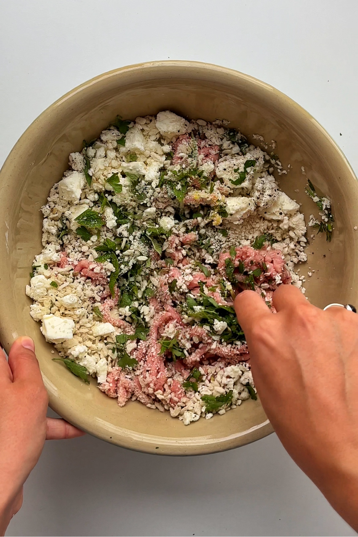 Combining meatball ingredients in a large bowl.