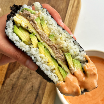Sushi onigirazu dipped in sriracha mayonnaise.