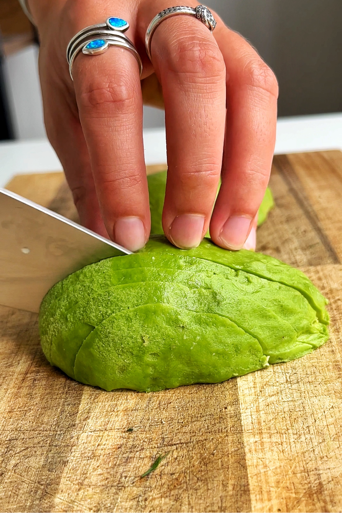 Slicing avocado on a wooden chopping board.