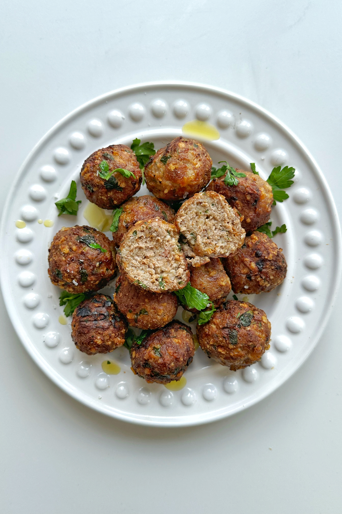 Turkey meatballs that have been air fried on a white plate.