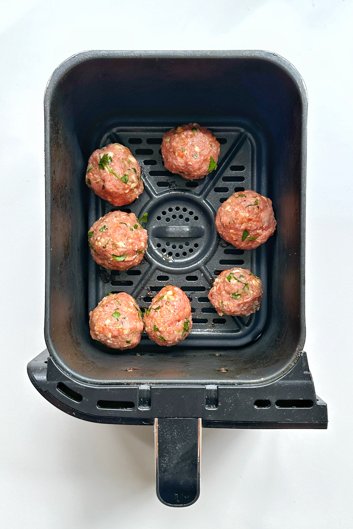 Turkey air fryer balls in the air fryer ready to be cooked.
