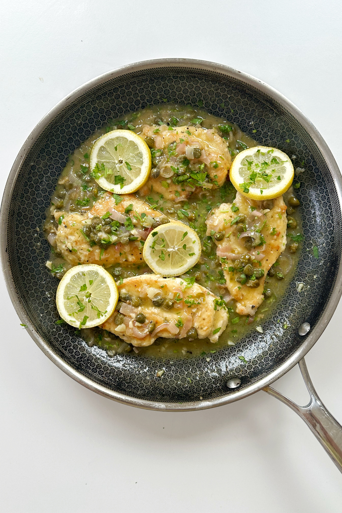 Chicken piccata in a skillet.