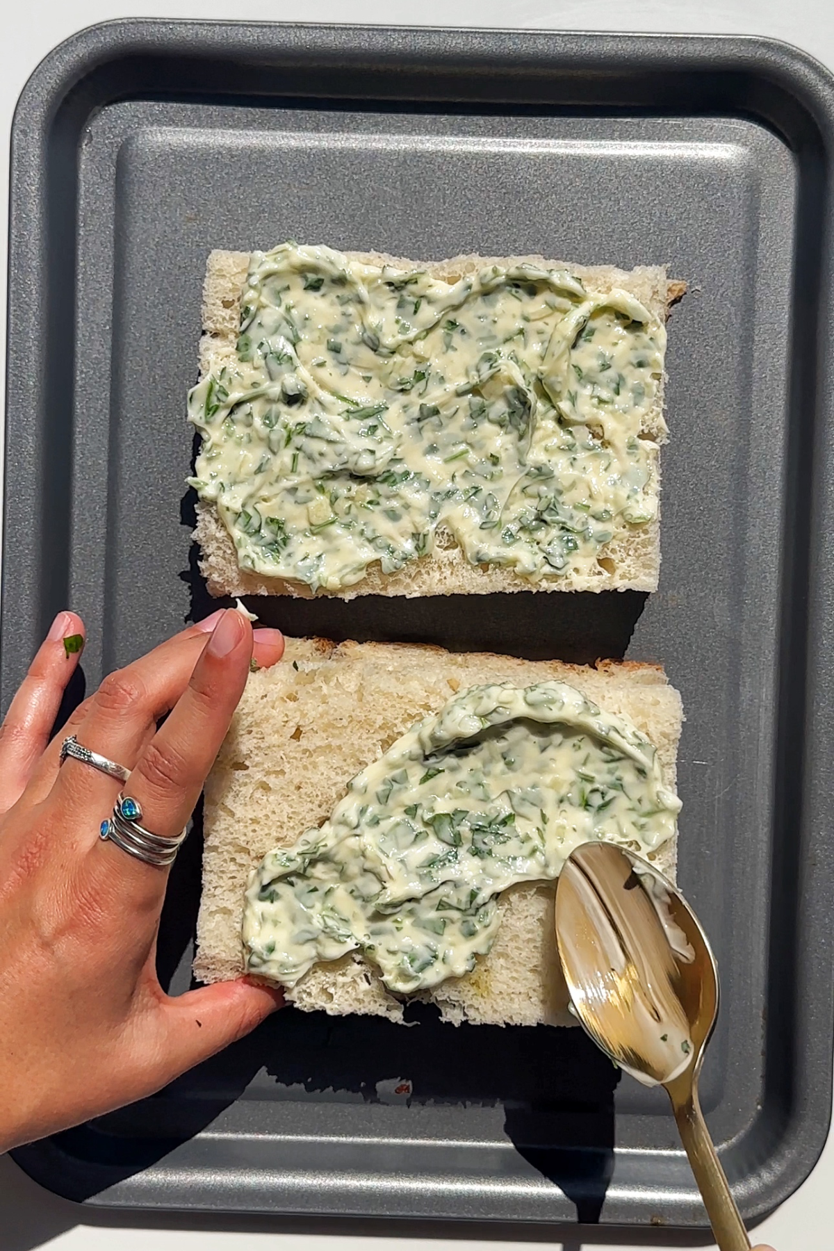 Spreading garlic parsley butter over focaccia.