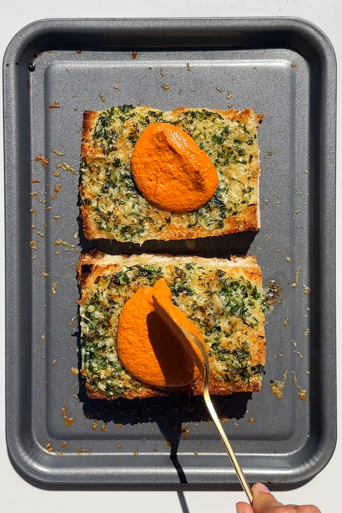 Spreading romesco sauce over the focaccia.