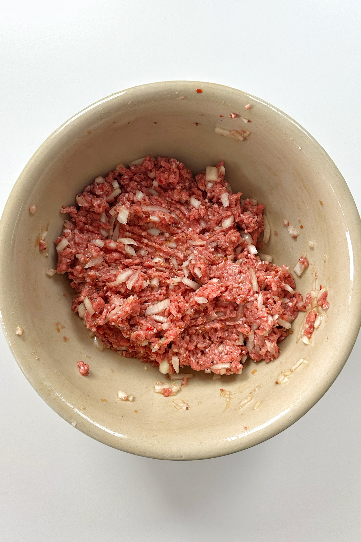 A large bowl filled with hamburger patty mixture.