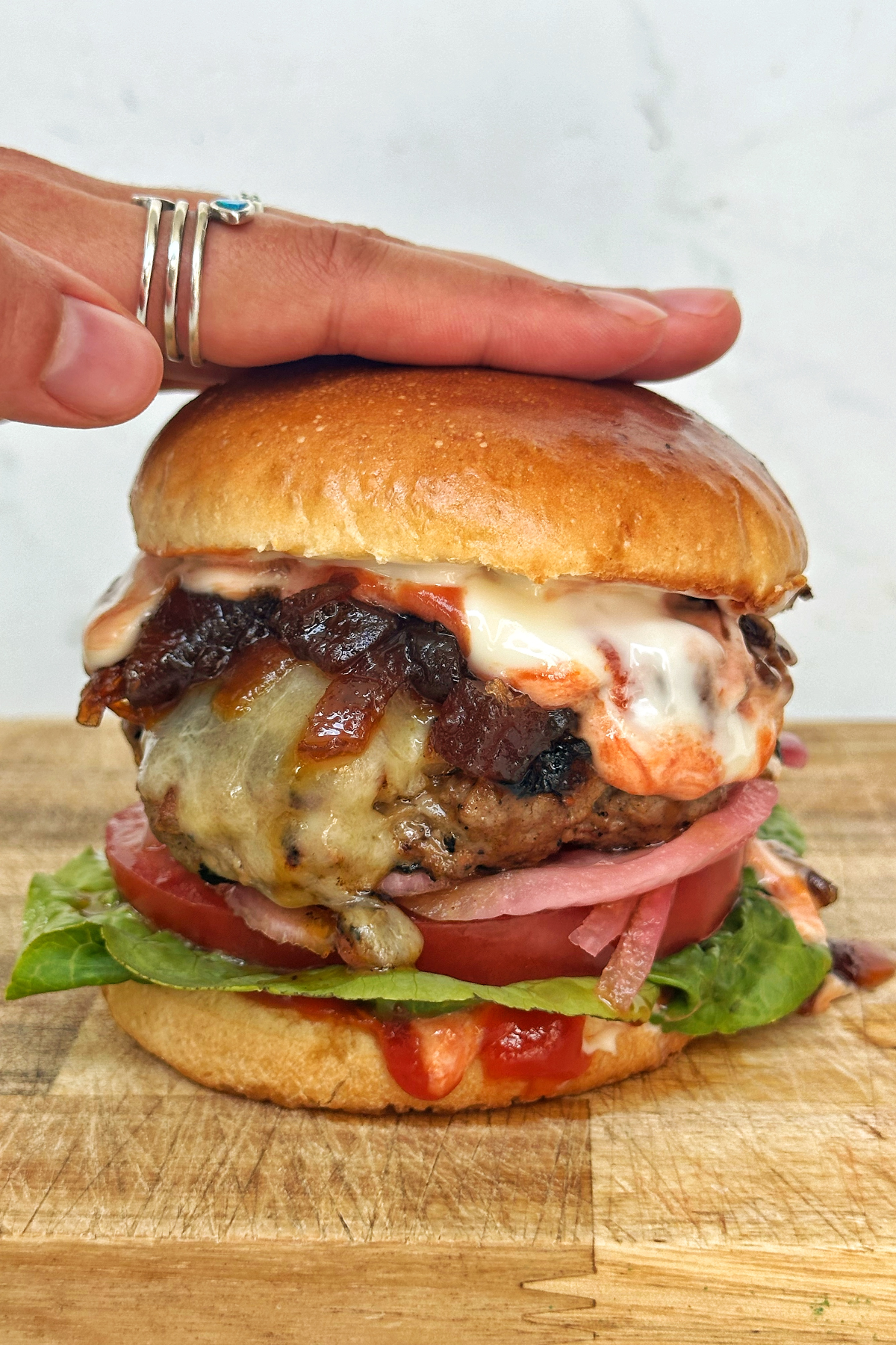 Hamburger patty in a bun with lettuce, tomato, onion.