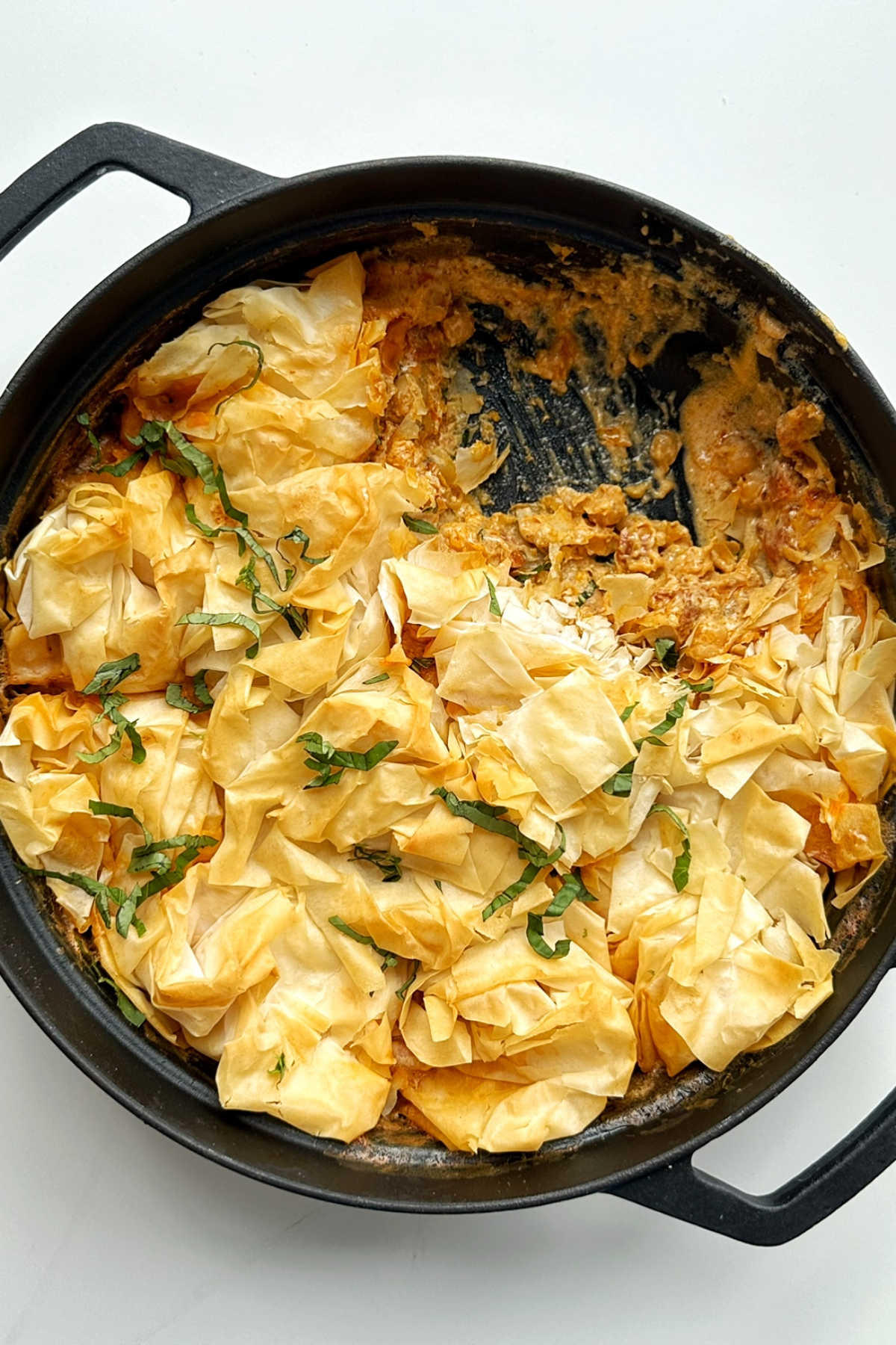 Prawn chorizo chickpea pie in a black ovenproof dish.