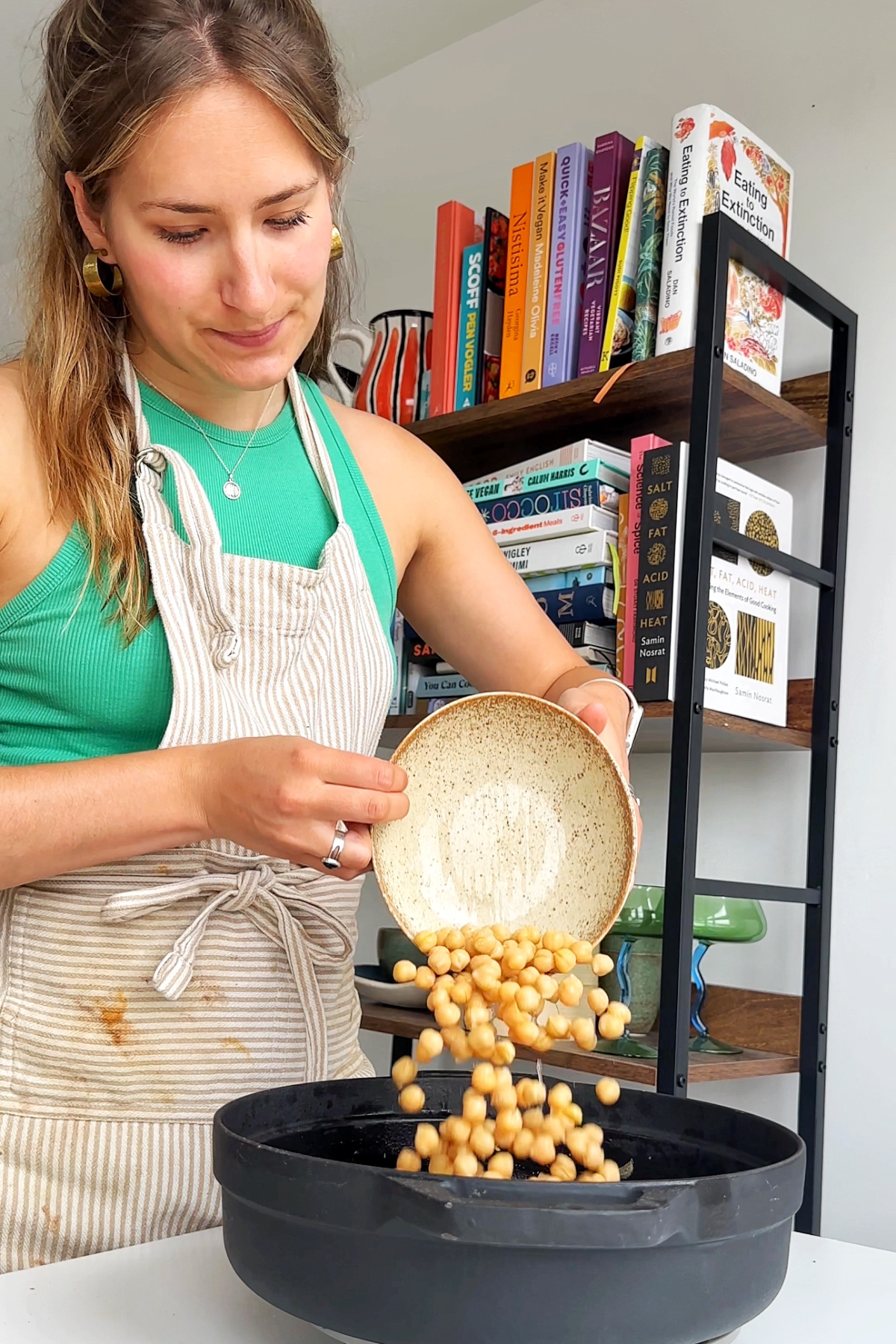 Adding chickpeas into an ovenproof dish.