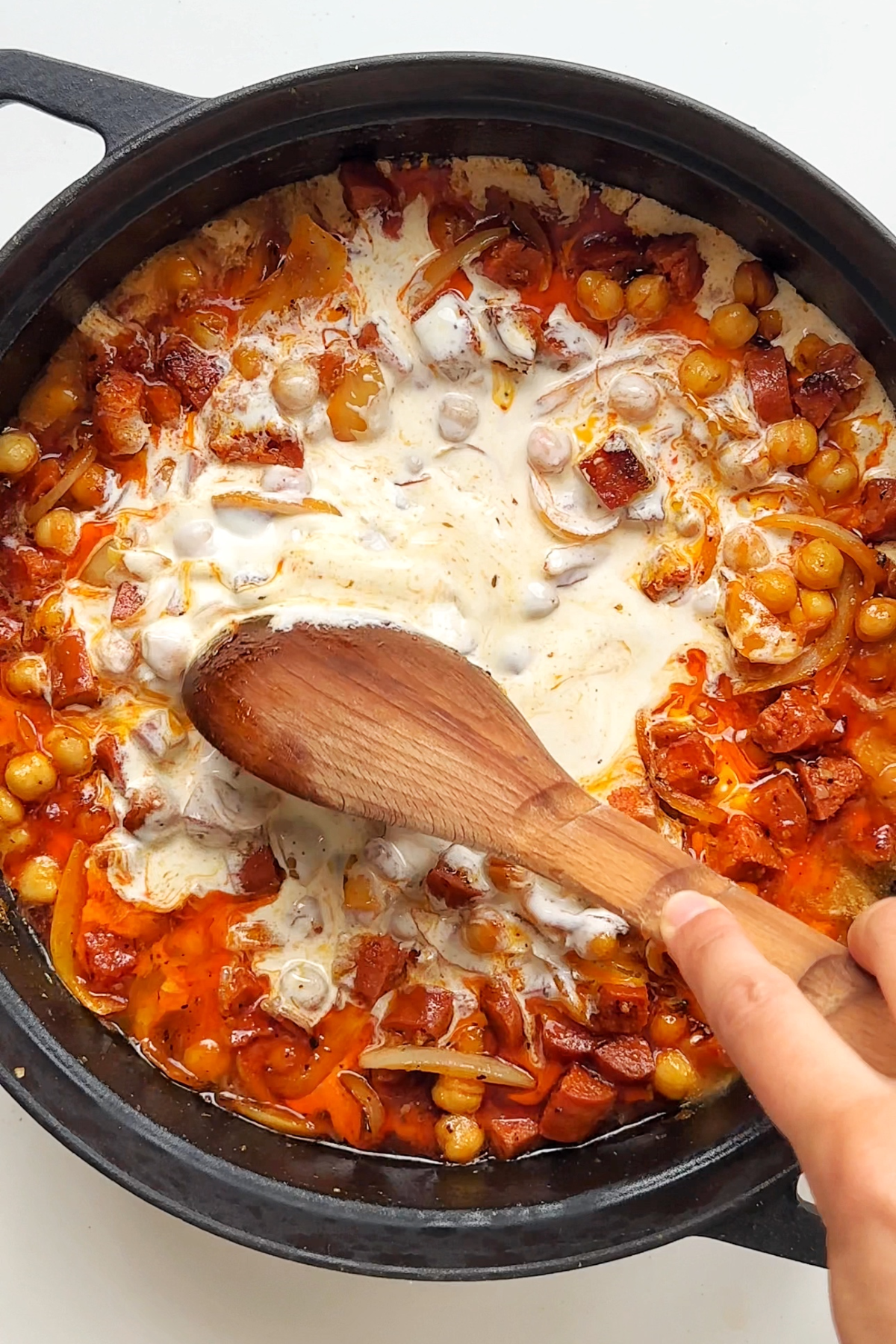 Combining cream in with a chickpea, prawn, and chorizo pie filling.