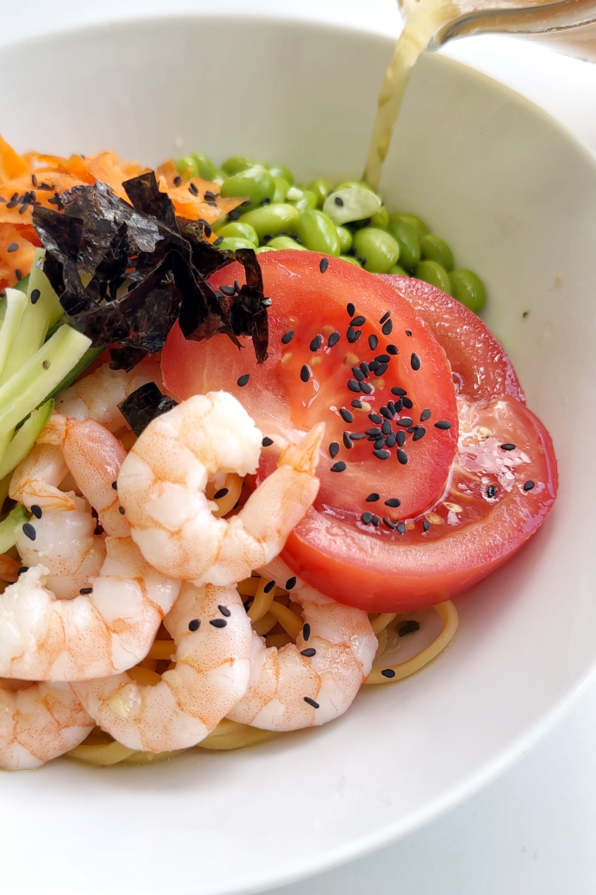 Pouring the cold ramen broth over the noodles.