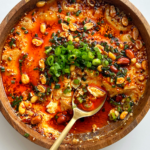 Steamed eggs recipe topped with chili oil, chives, and green onions.