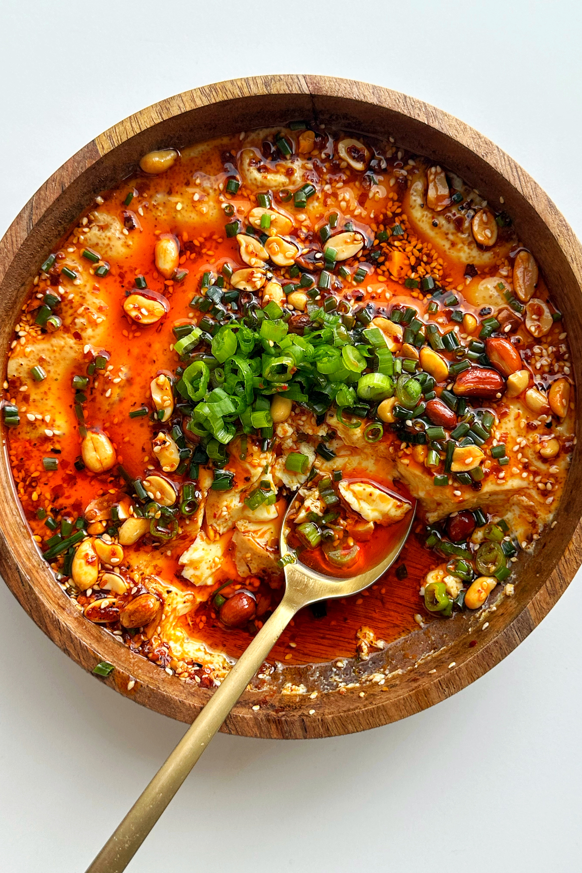 Steamed eggs recipe topped with chili oil, chives, and green onions. 