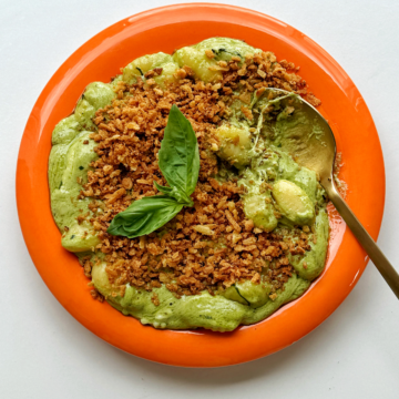 Pesto gnocchi with golden spoon.