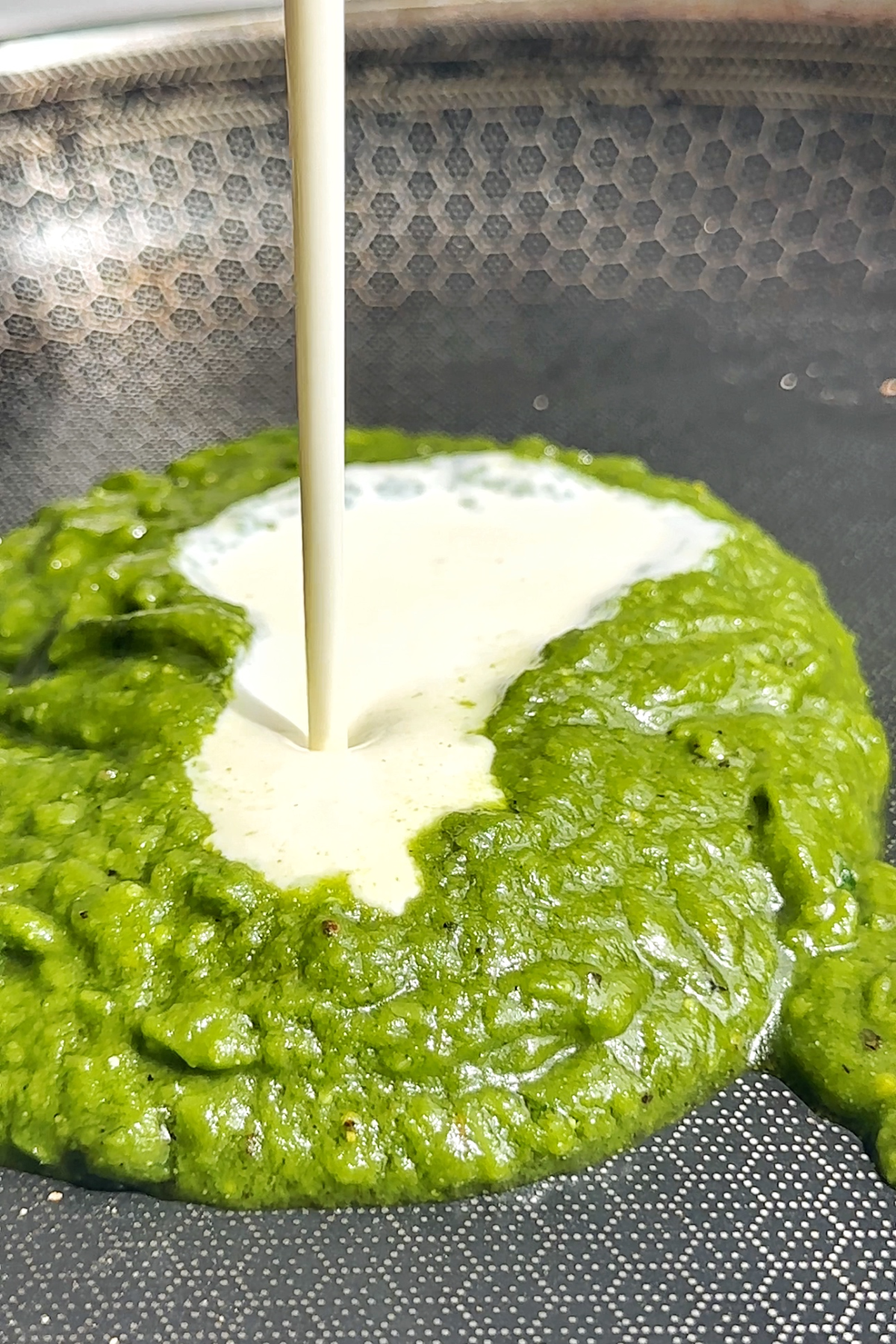 Pouring cream into homemade pesto.
