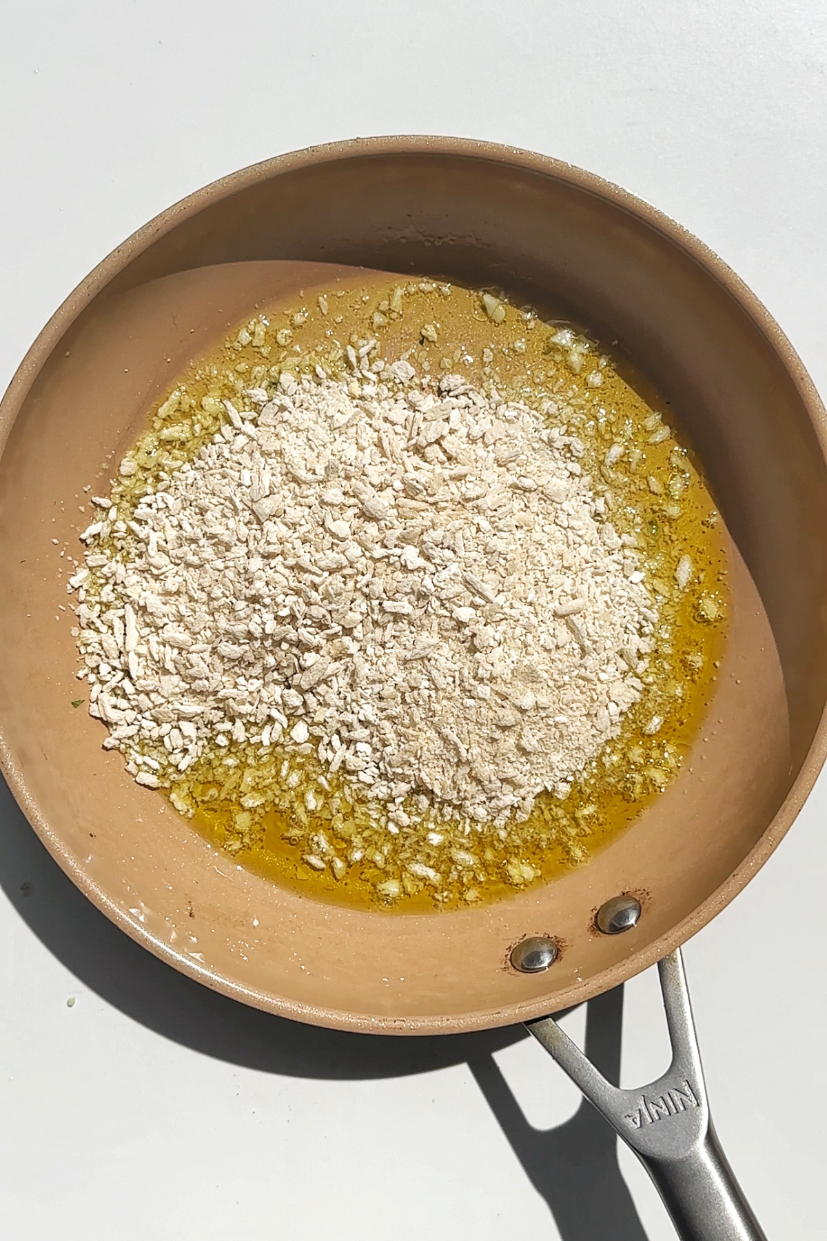 Toasting breadcrumbs in a pan.