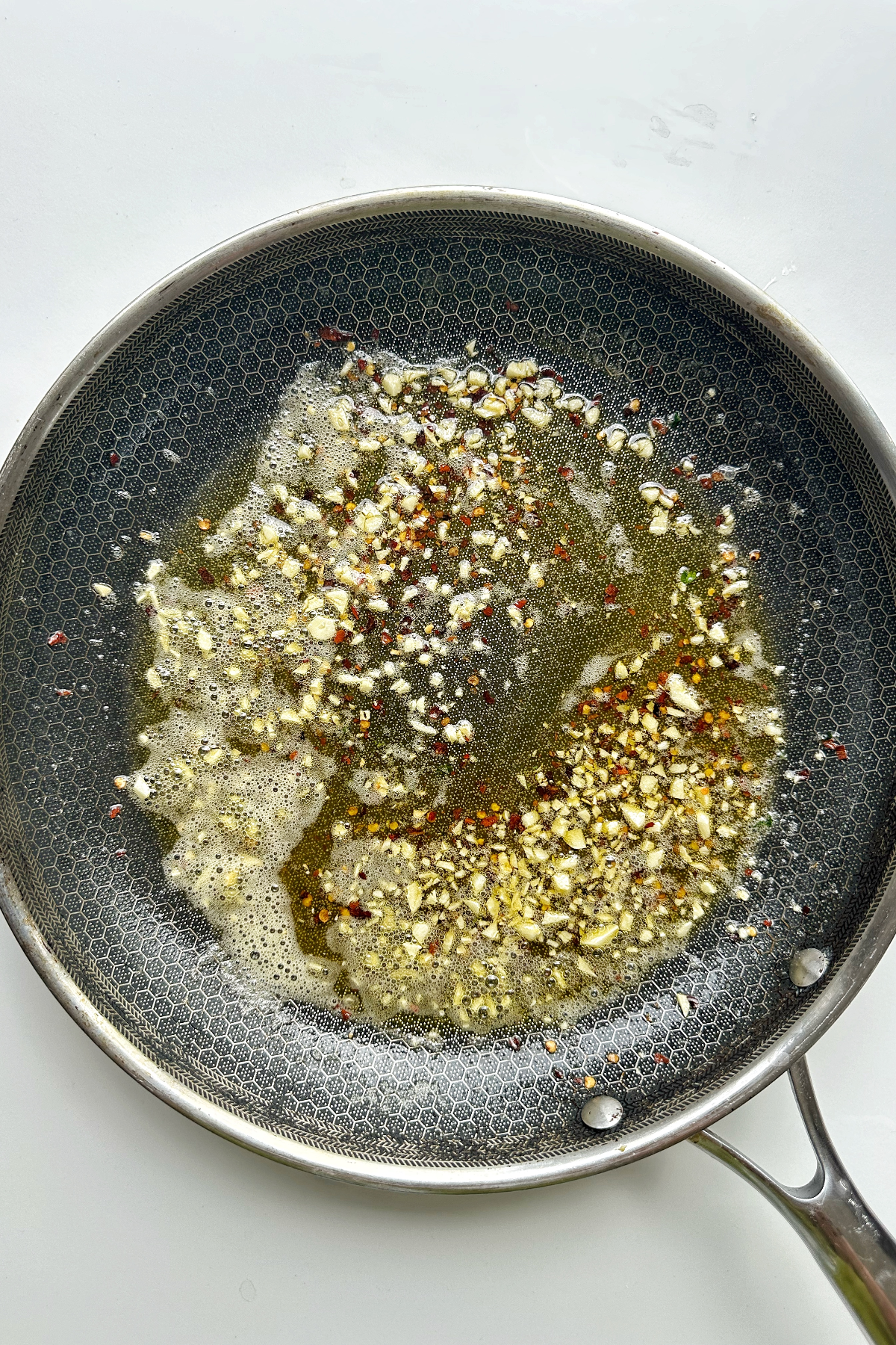 Frying garlic, butter, and olive oil in a pan.