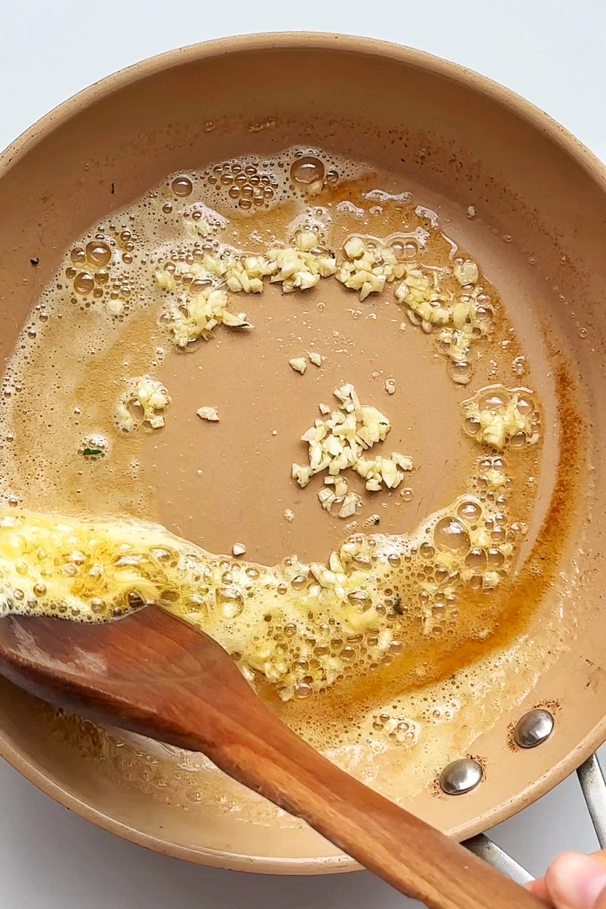 Frying butter and garlic in a frying pan.