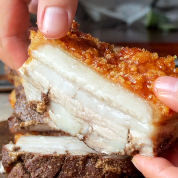 Holding up crispy pork belly to the camera.
