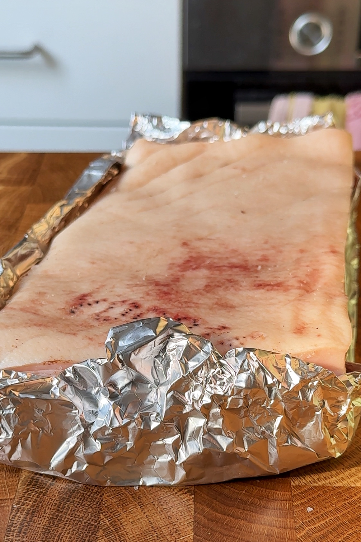 Covering the sides of air fryer pork belly with tinned foil.