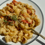 Goat cheese pasta with golden fork topped with dill and lemon zest.