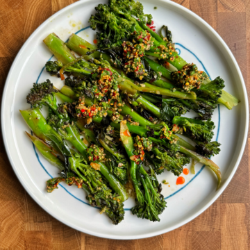 Top down shot of stir-fried broccolini (tender stem broccoli) with a spicy sauce.