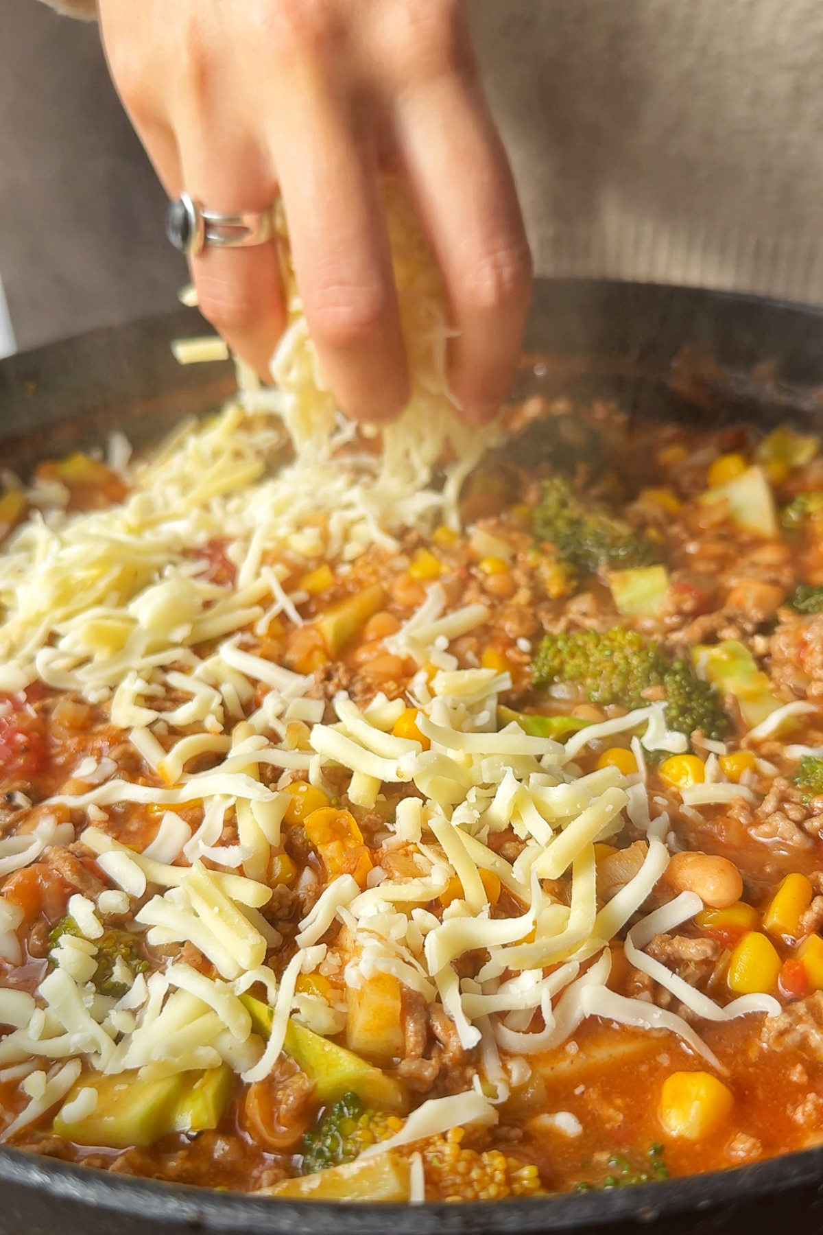 Topping the cowboy casserole with cheese.