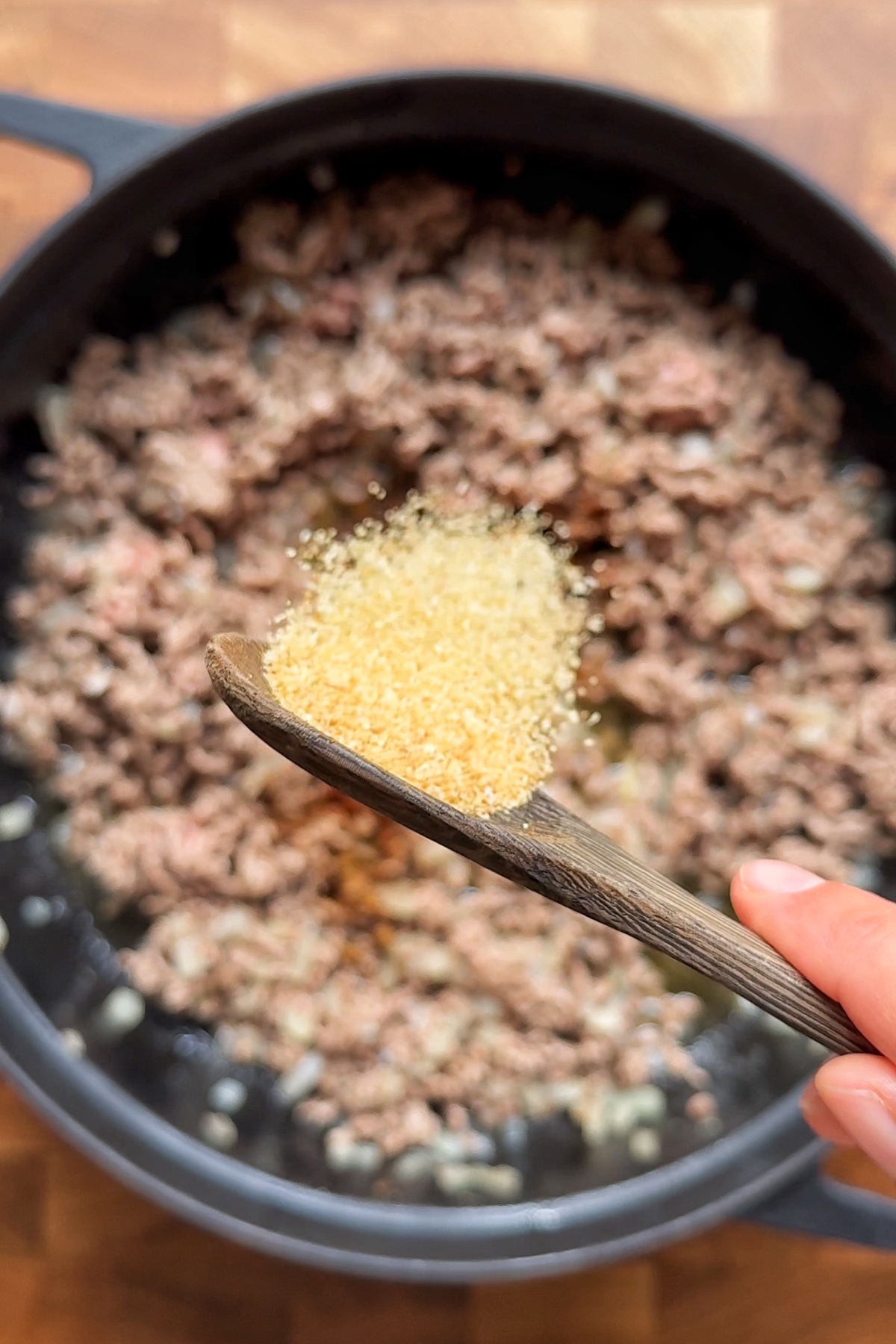 Adding seasonings into the cowboy casserole mixture.
