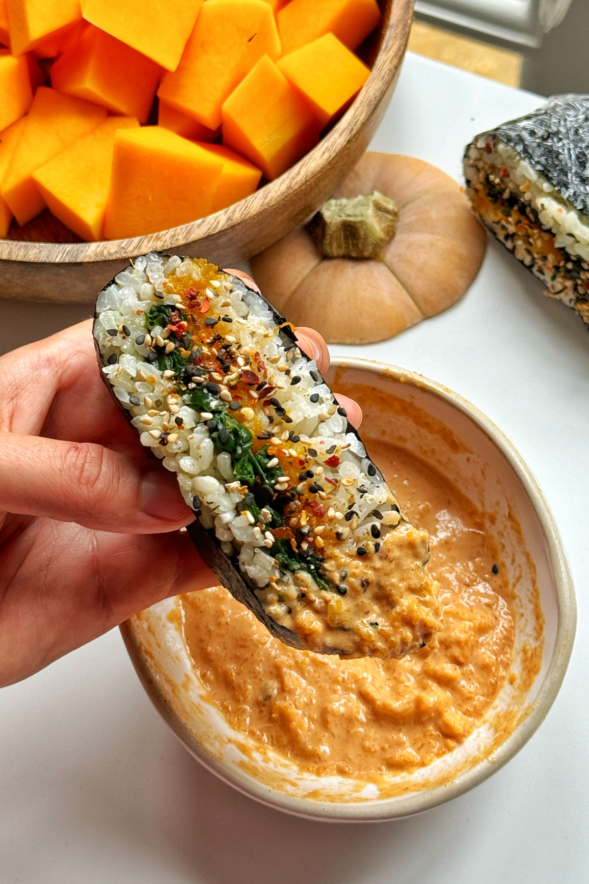 Dipping sushi sandwich in a sauce.