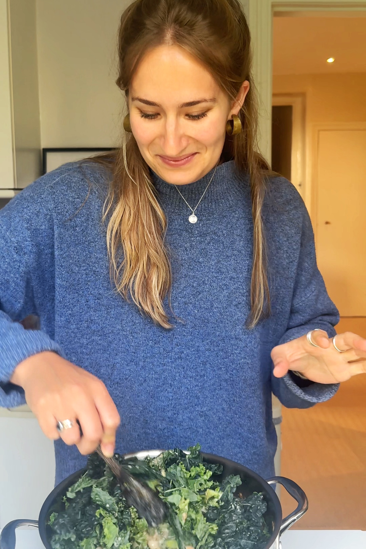 Stirring kale into the soup.