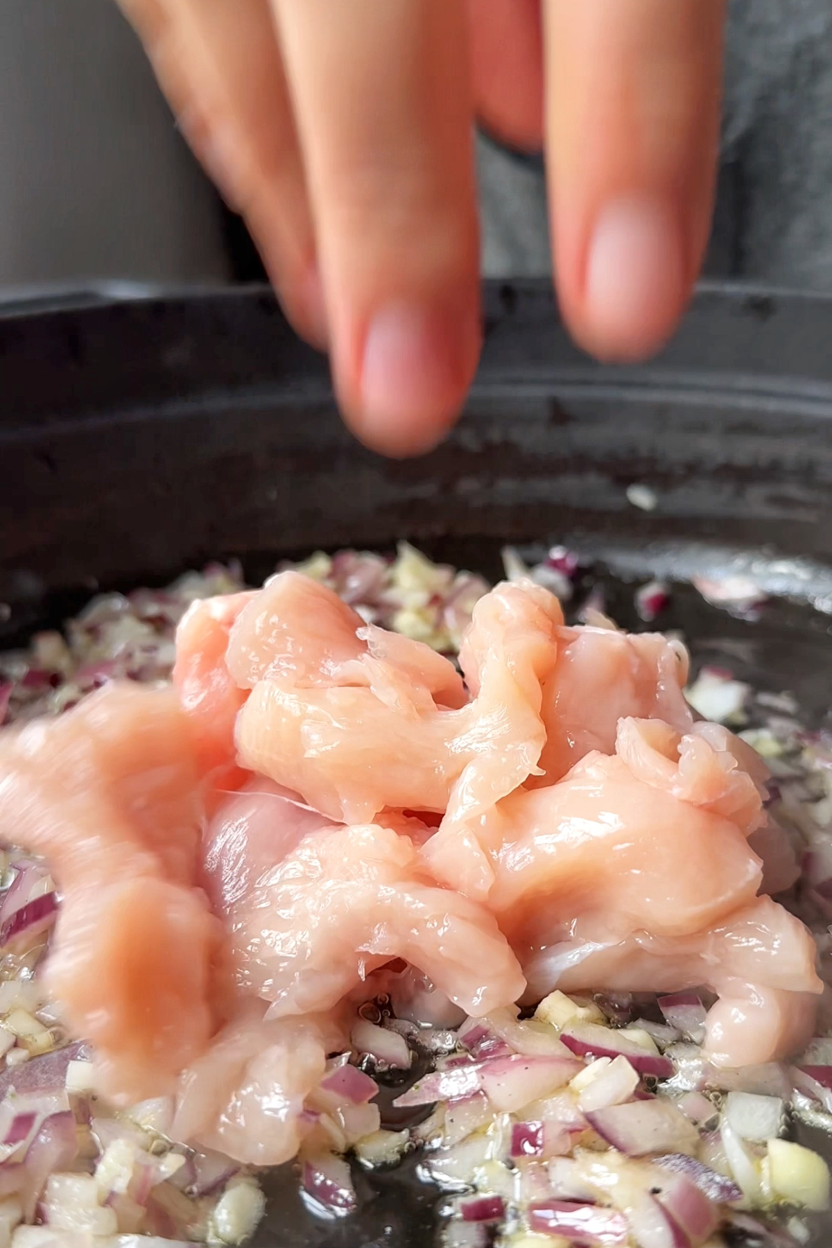 Adding chicken into the chicken and broccoli pasta.