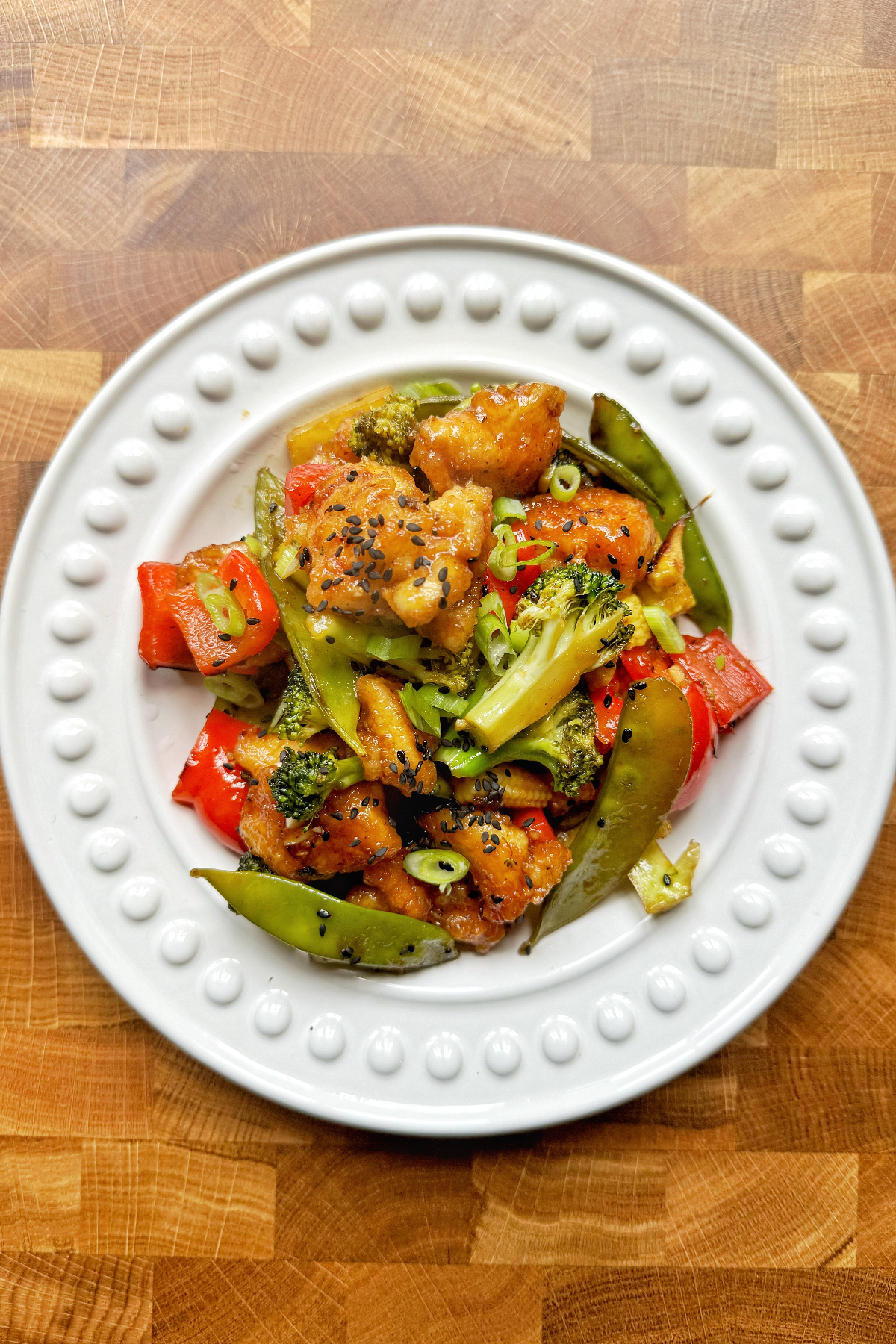 Teriyaki chicken stir fry served in a white bowl.
