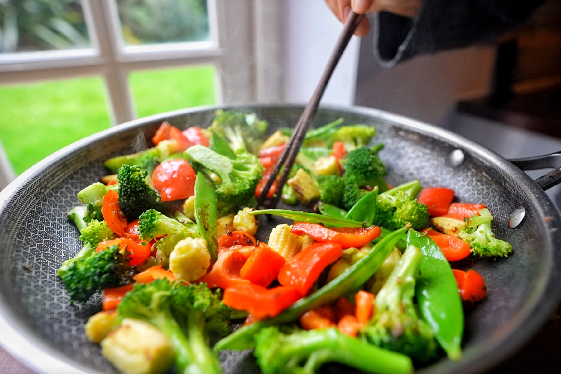 Stir frying vegetables in a pan.