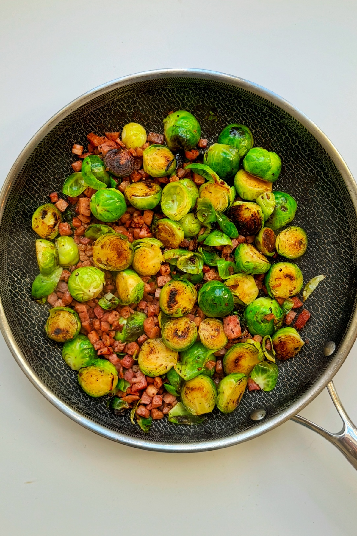 Frying brussels sprouts and bacon.