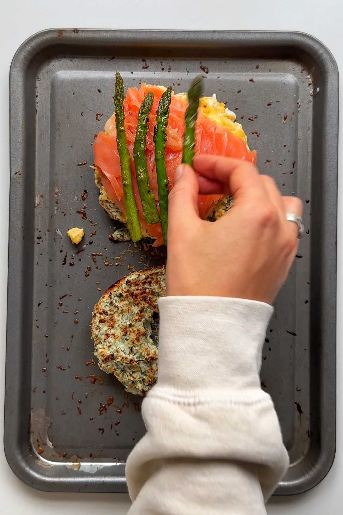 Layering the smoked salmon bagel with all of it's components.