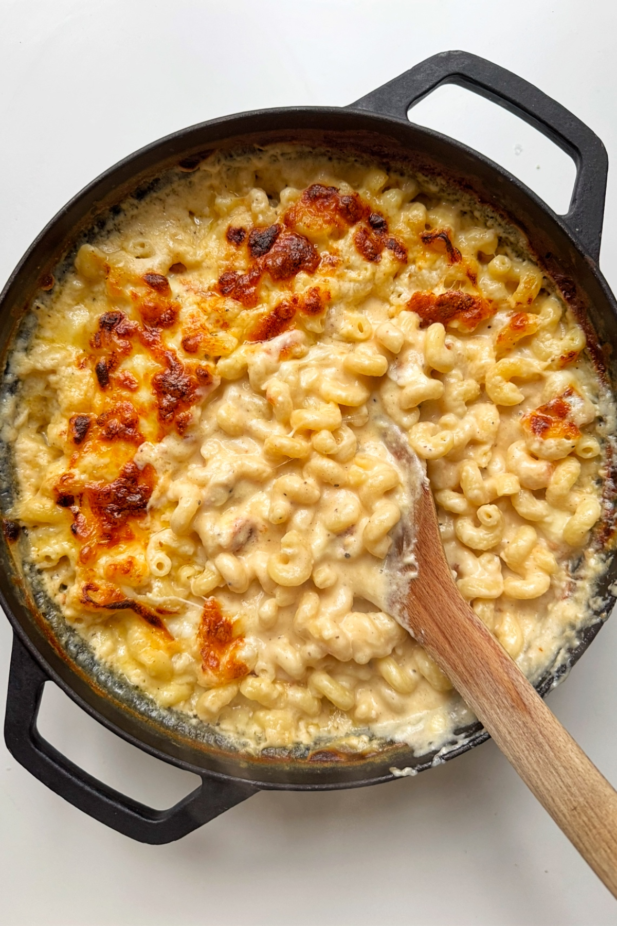 Black oven-proof dish filled with macaroni and cheese.