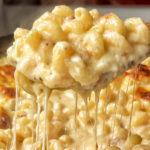 Black oven-proof dish filled with macaroni and cheese pull.