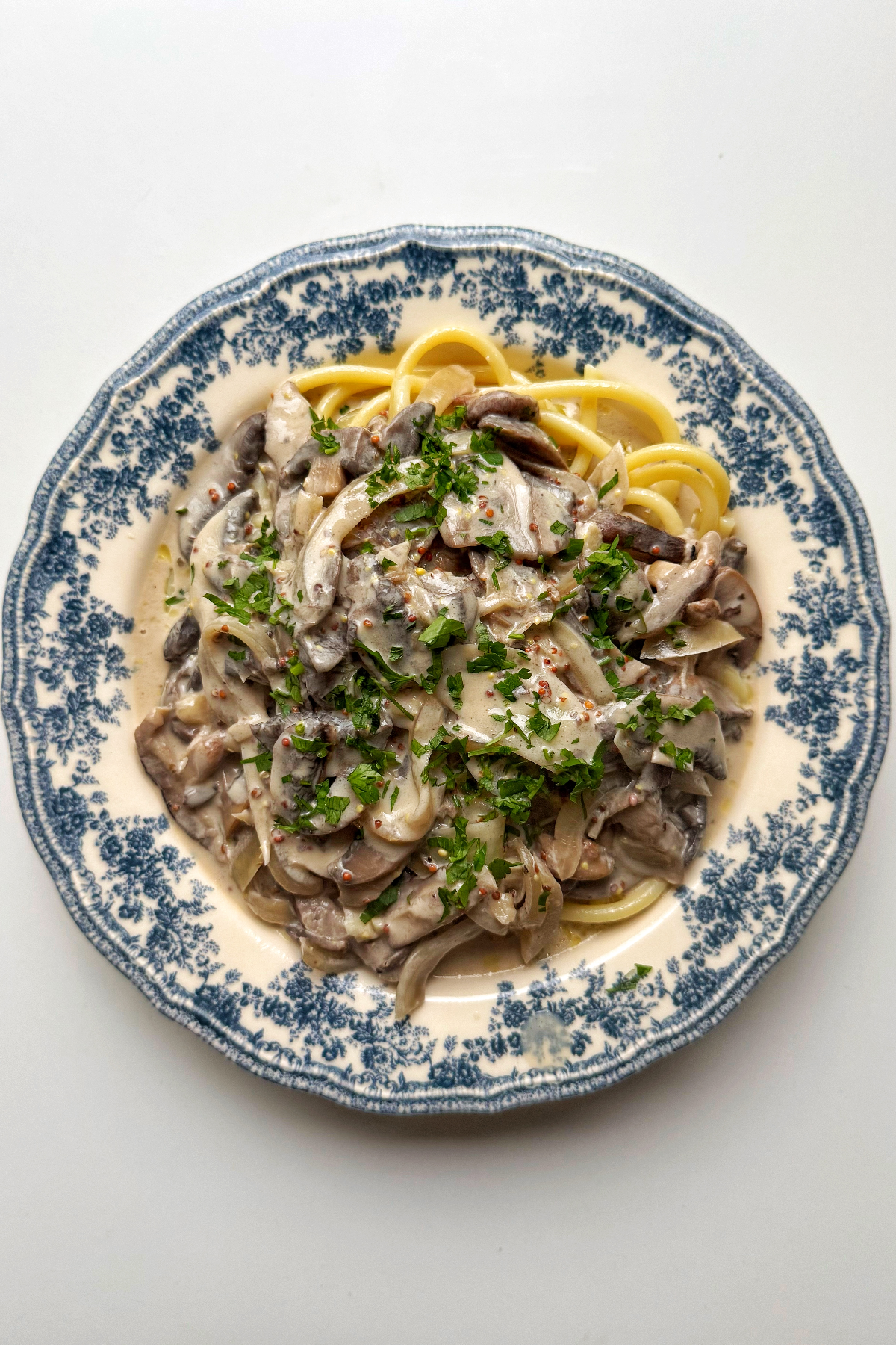 vegan mushroom stroganoff on a blue and white plate. 