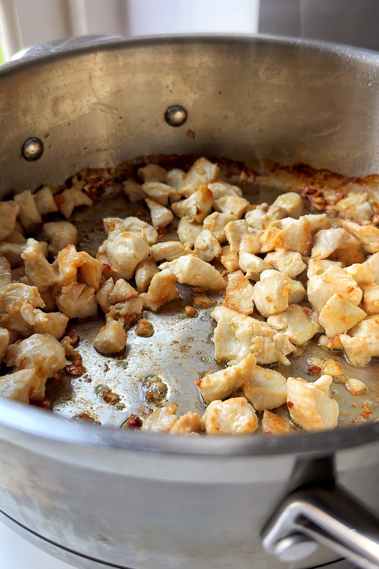 Cooking chicken for chicken pasta alfredo with broccoli.