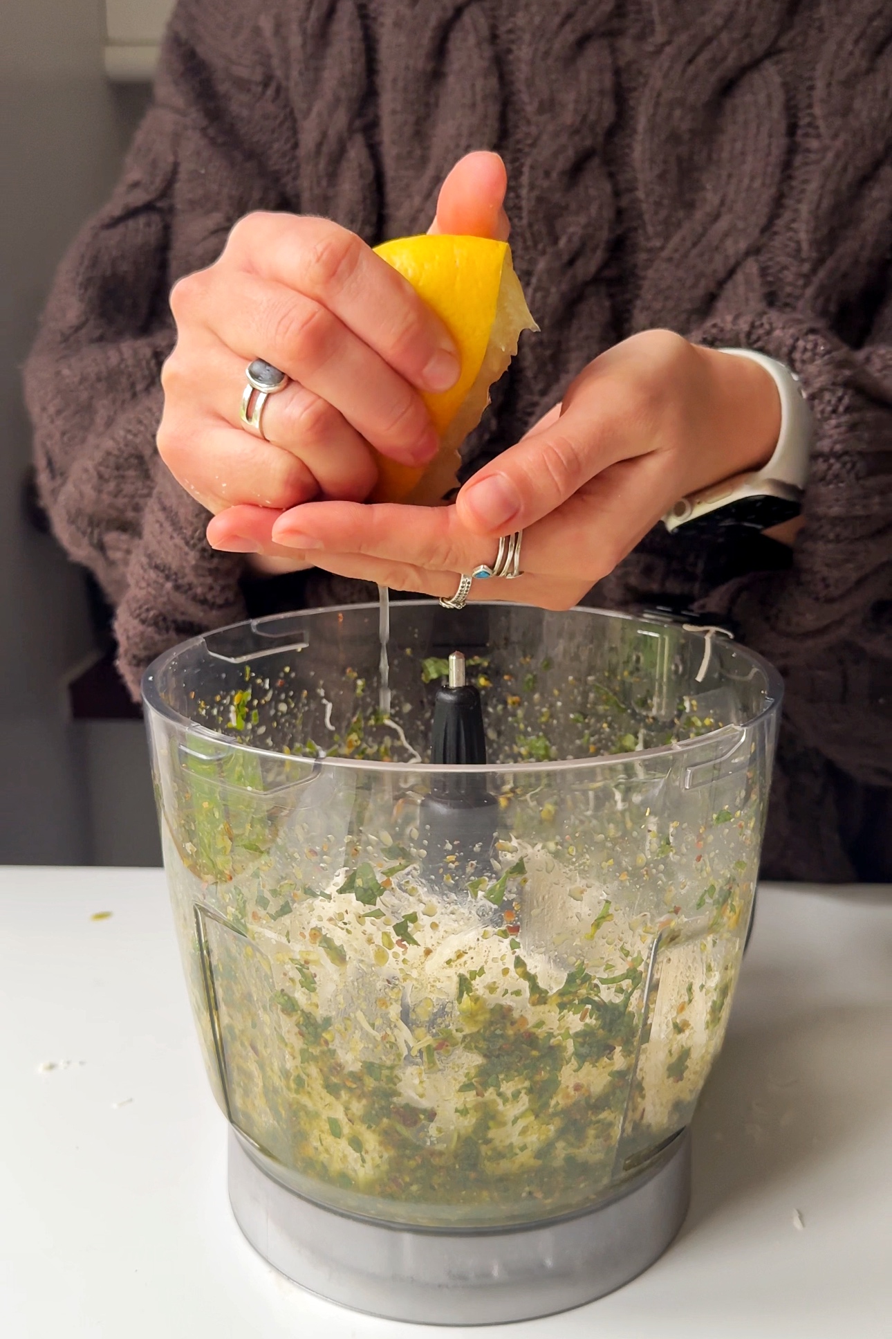 Adding parmesan and lemon juice to the pistachio pesto mixture.