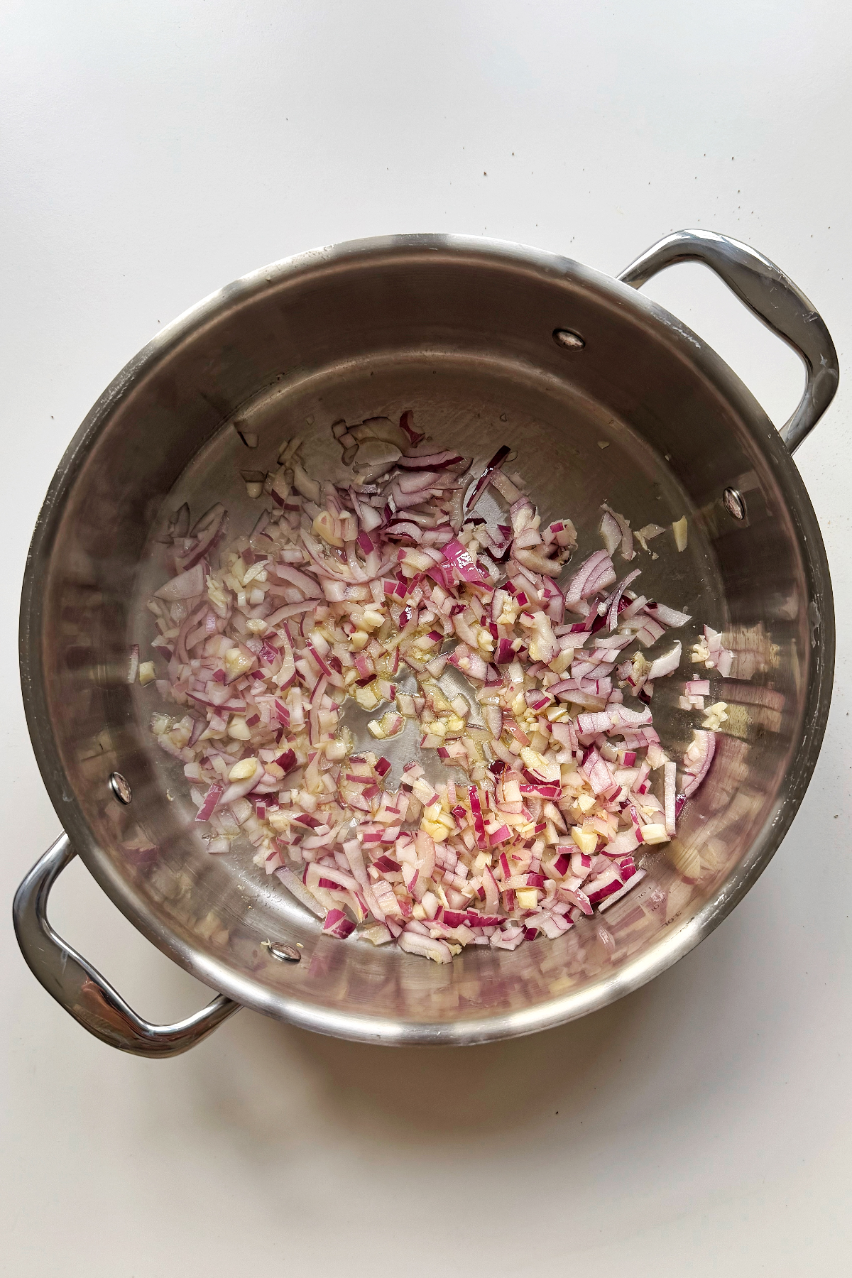 Frying onion and garlic in a metal pan.