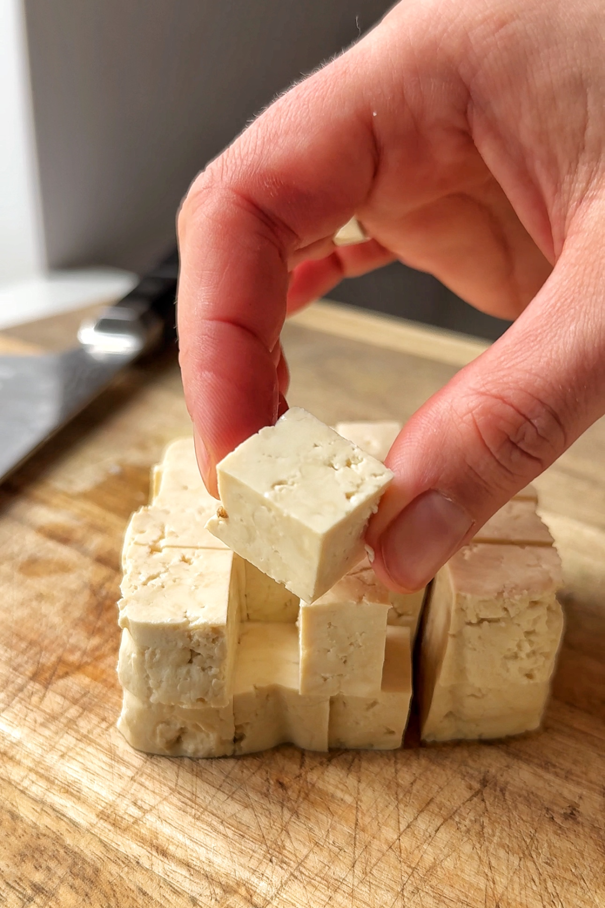 Slicing tofu into cubes.