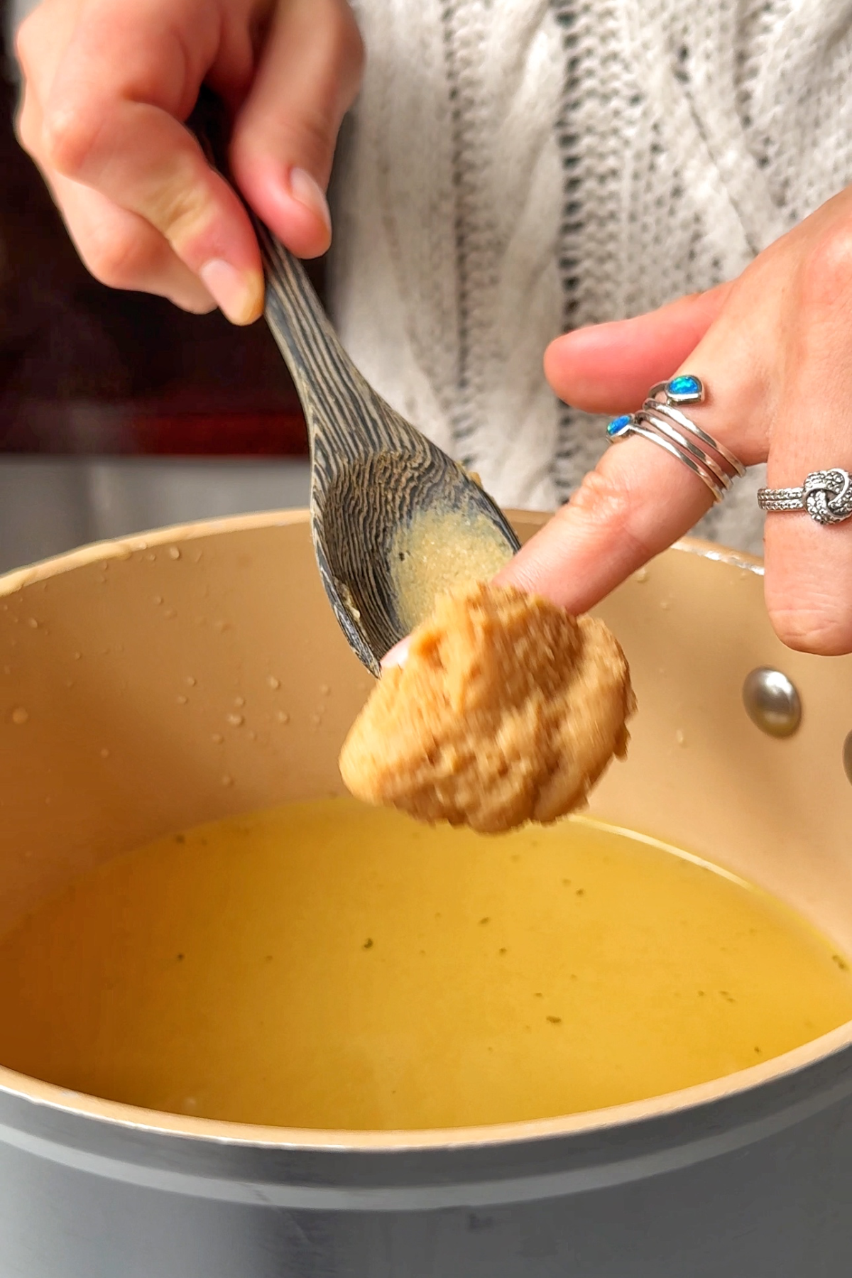 Adding miso to vegetable broth.