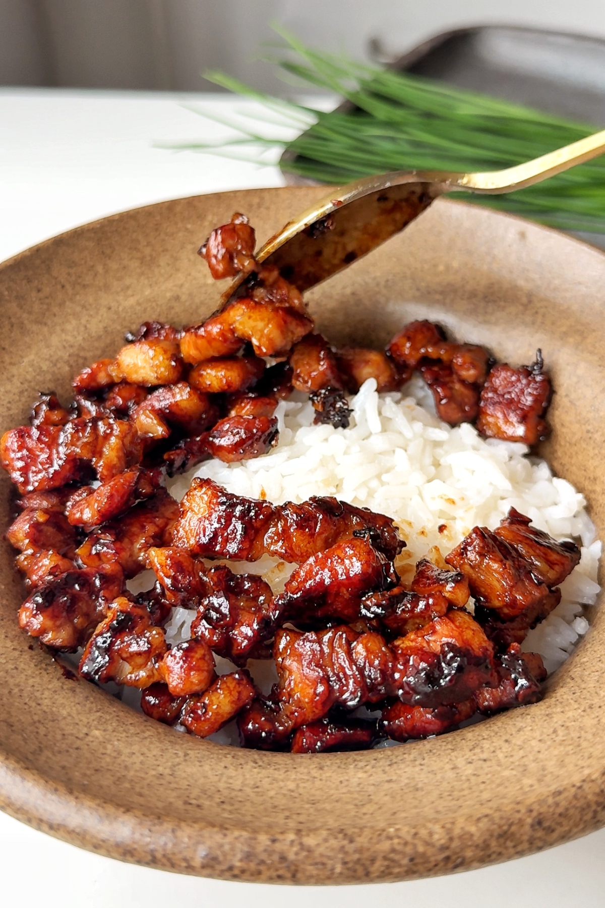 Placing pork belly on top of rice.