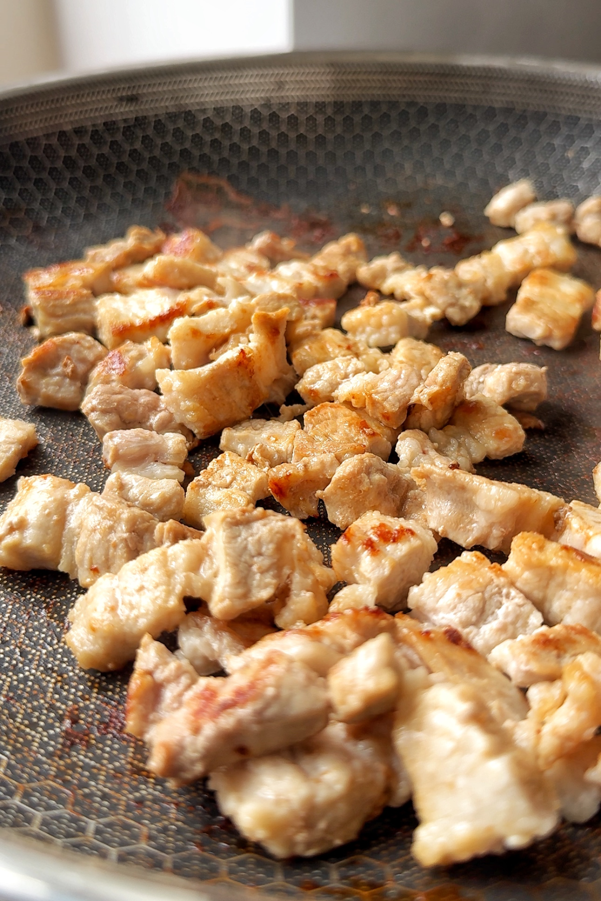 Fry pork belly until it's golden and slightly seared.