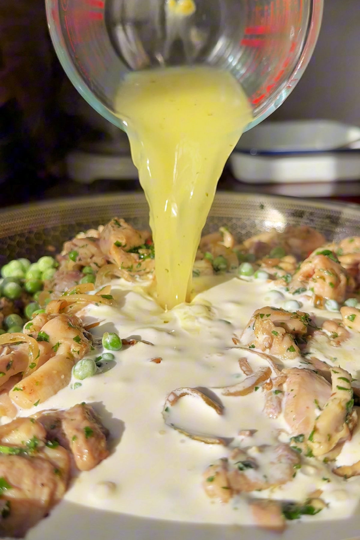 Pouring chicken stock into our chicken pot pie filling pan.