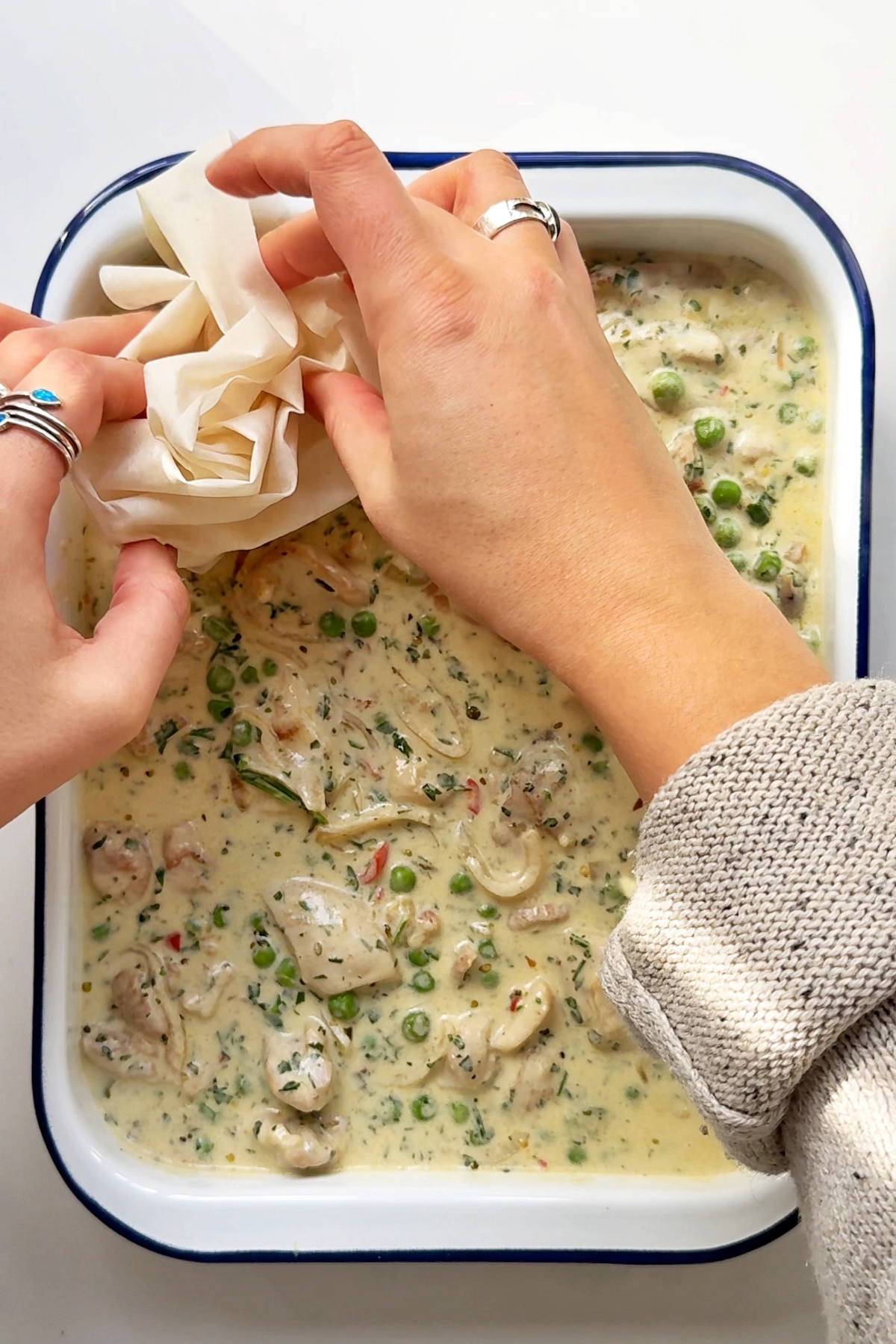 Scrunching up filo dough and placing it down onto the chicken pot pie filling.