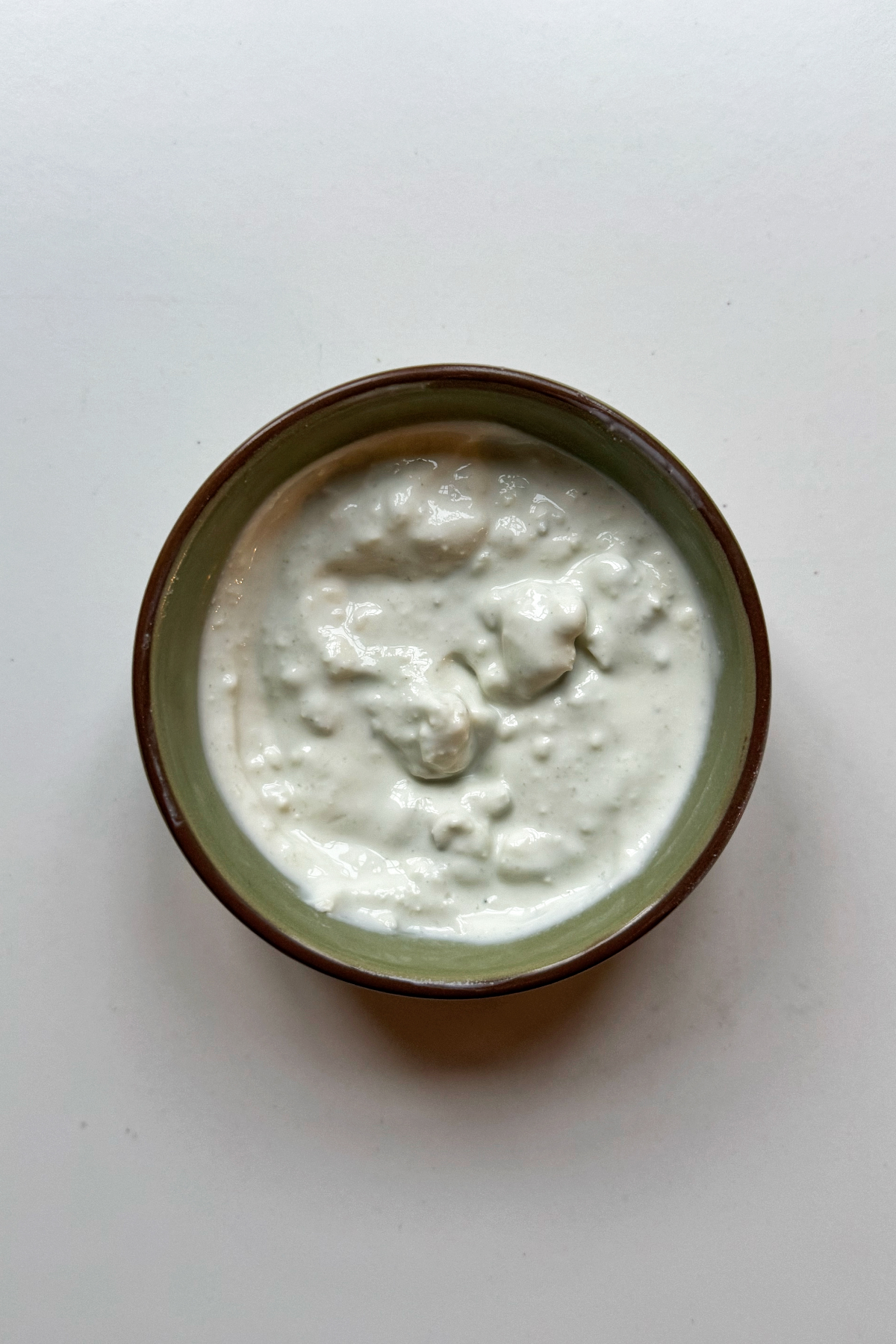 Homemade blue cheese sauce in a green bowl.