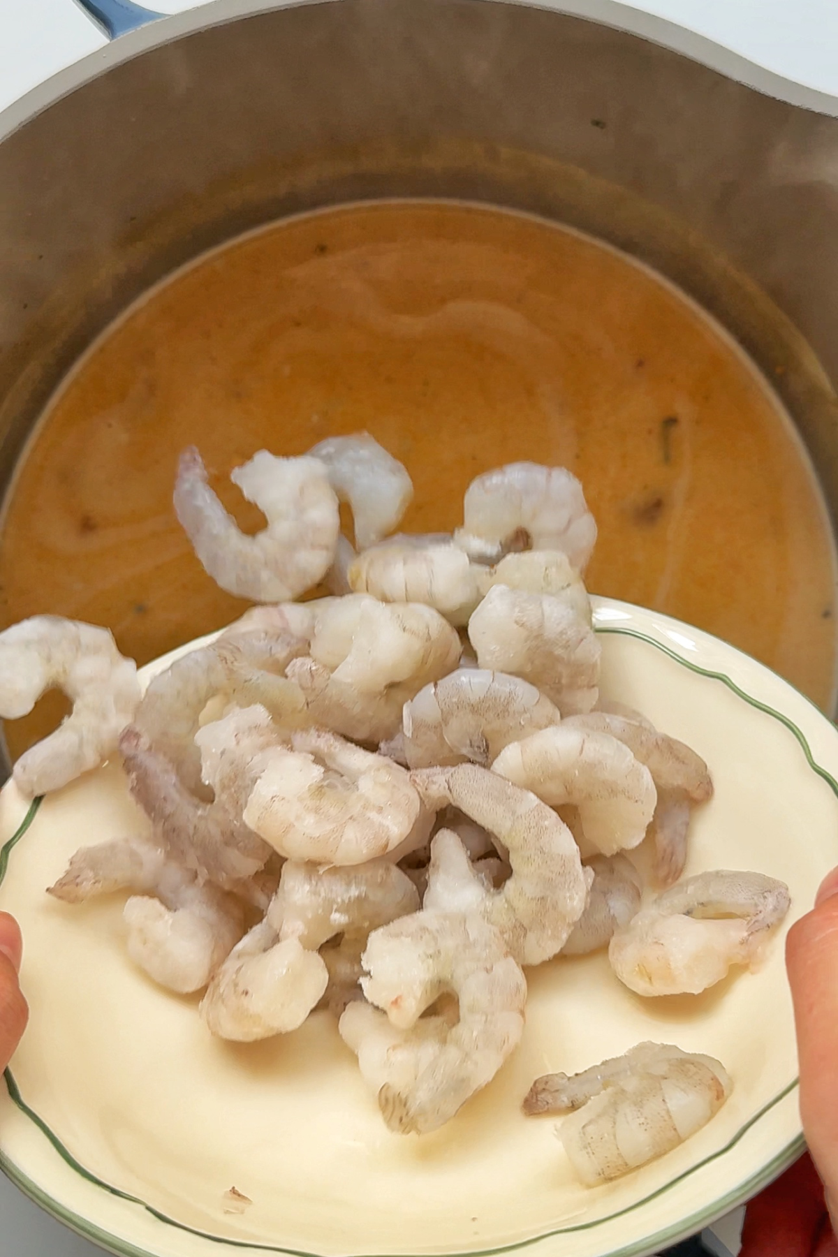 Adding shrimp to our broth.