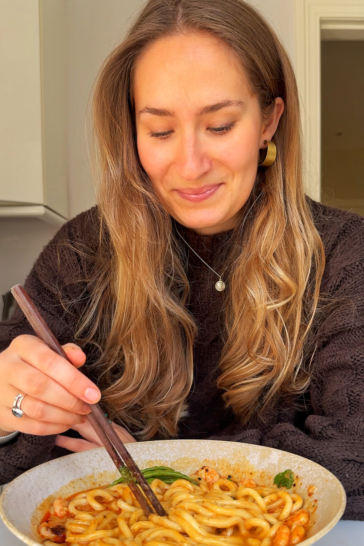 Emily Roz enjoying shrimp with ramen noodles.